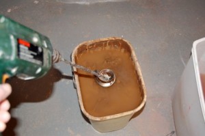 The bucket of scrap clay just before mixing. Into the bucket goes all scraps, the slurry water from the splash pan and the water from my little bucket I use when at the potter's wheel. Nothing goes down the drain! Note the clumps of clay just under the water line.